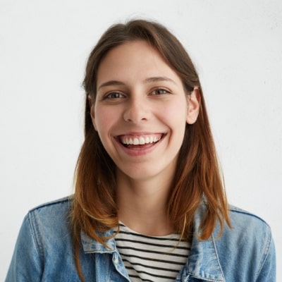 Smiling person in denim jacket and striped shirt