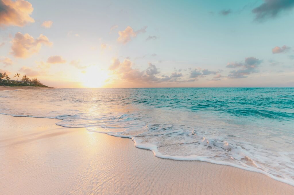 Serene beach sunrise with gentle ocean waves.