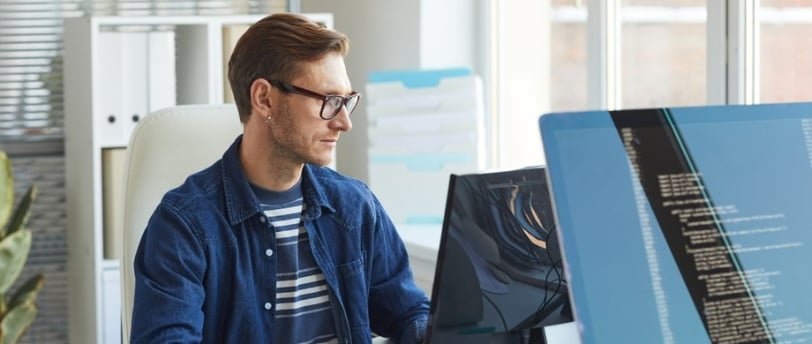Person coding on computer at desk.