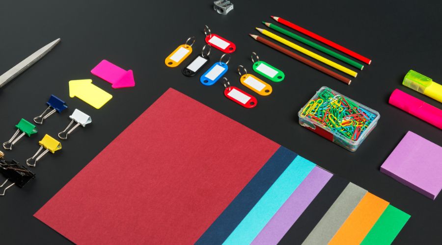 Colorful stationery supplies on black background