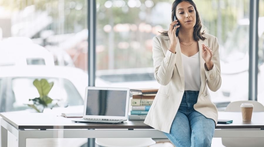 Woman talking on phone at a desk.