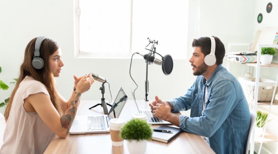 Two people recording podcast in studio setting.