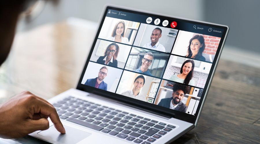 Laptop screen showing virtual meeting with participants.