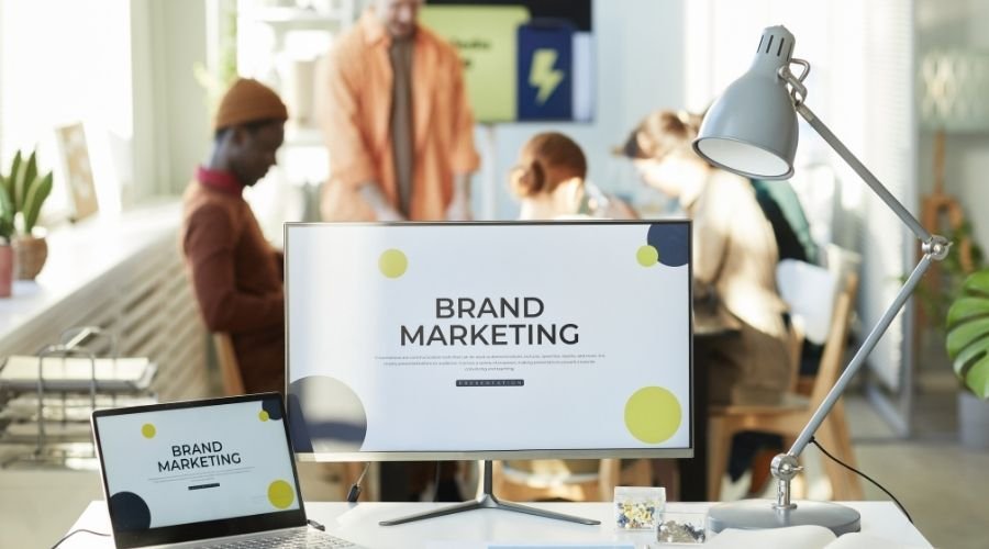 Office workspace with brand marketing screen.
