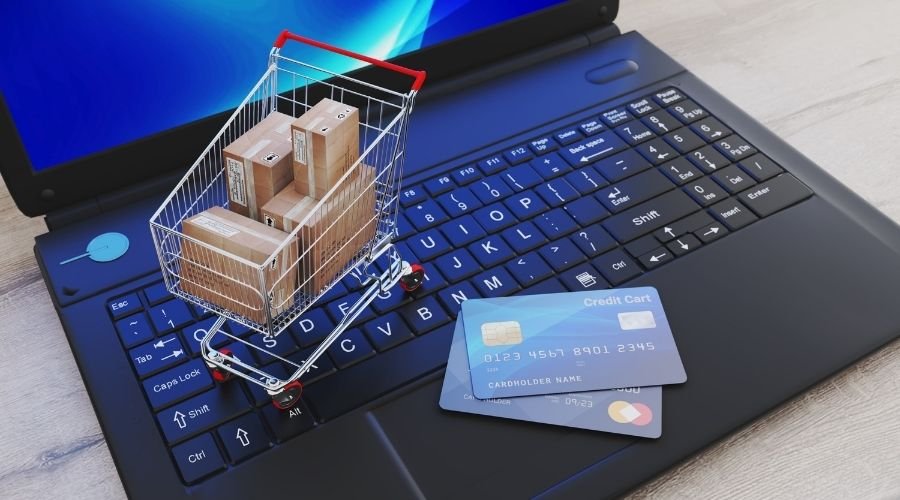 Online shopping concept with cart on laptop.