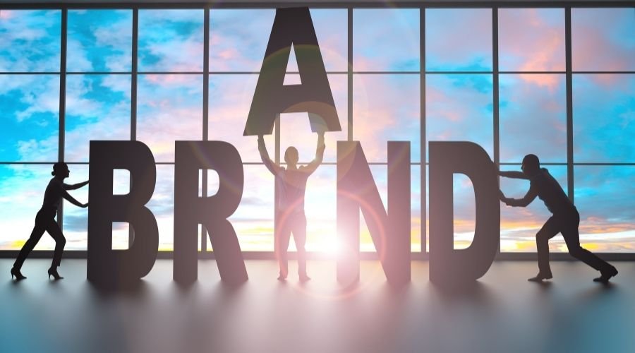 People lifting brand letters in front of window.