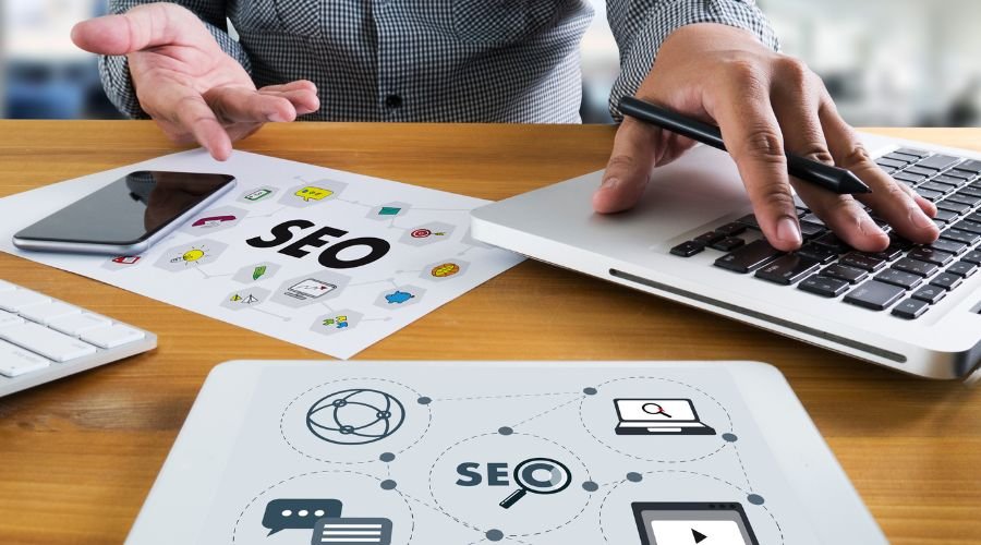 Person working on SEO strategies with tablet and documents.