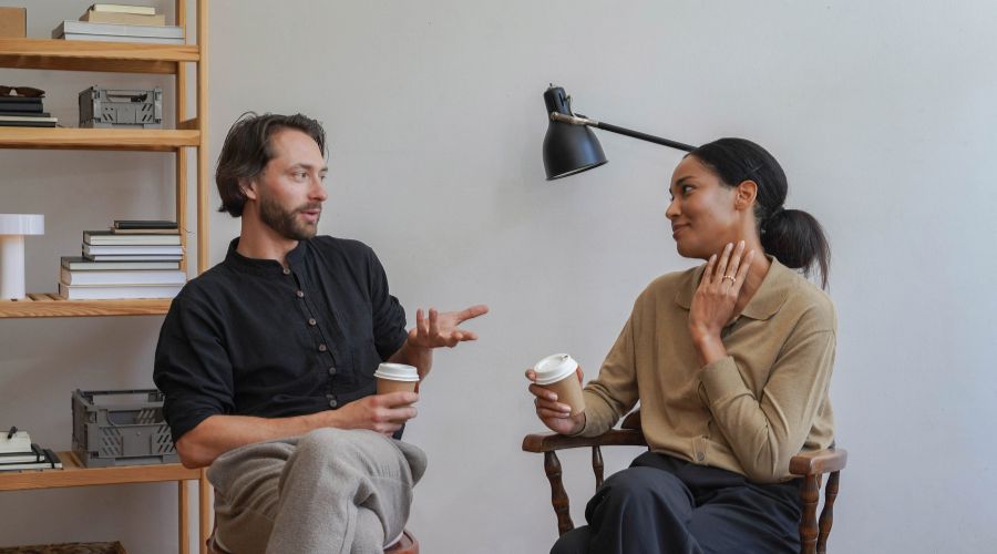 Two people talking with coffee in hand