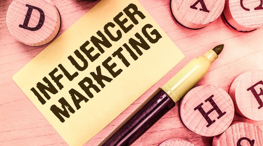 Influencer marketing concept with pen and wooden blocks.