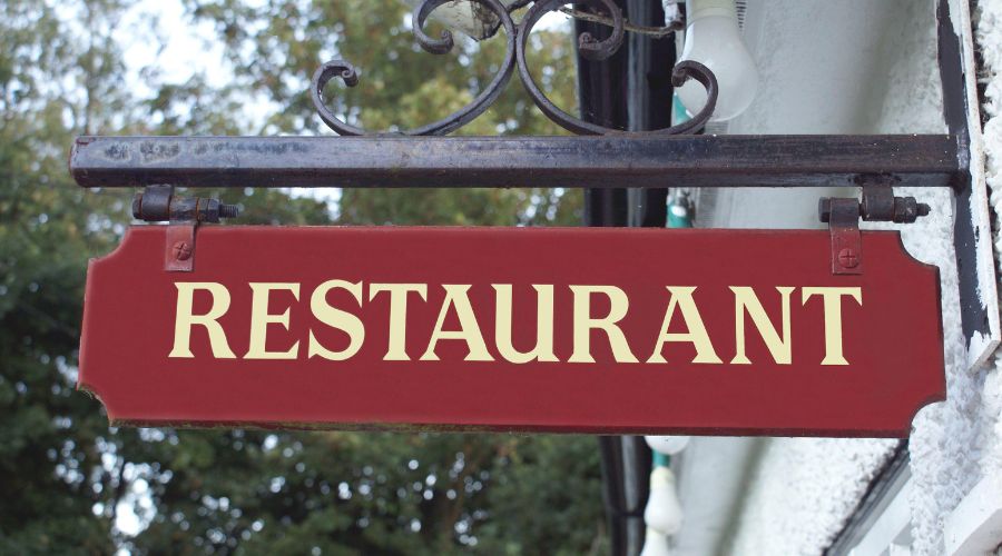 Red restaurant sign hanging outdoors