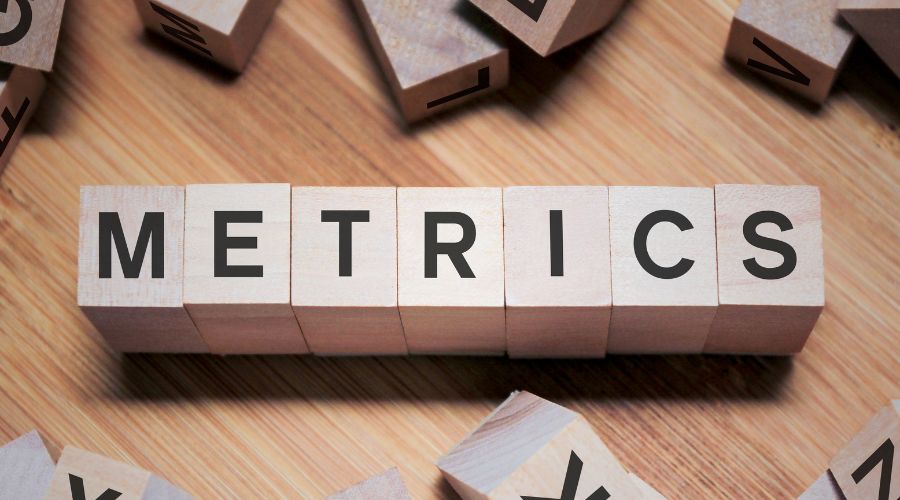 Wooden blocks spell 'Metrics' on table.