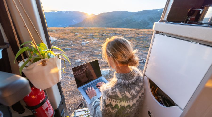 Person working remotely from a van during sunrise.