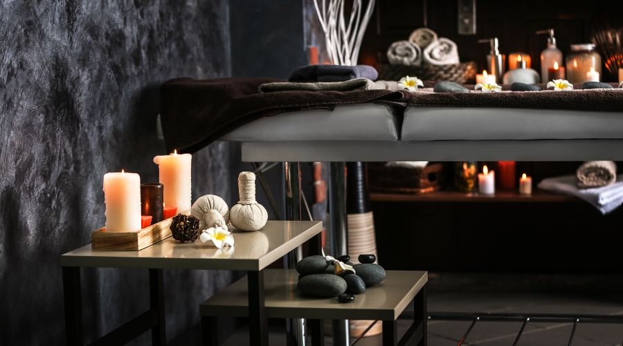 Cozy spa room with candles and massage table.