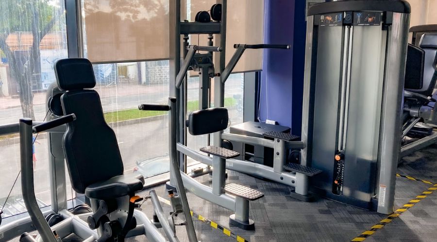 Modern gym equipment with various exercise machines.