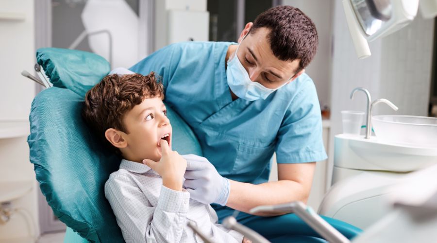 Dentist examining child's teeth in clinic