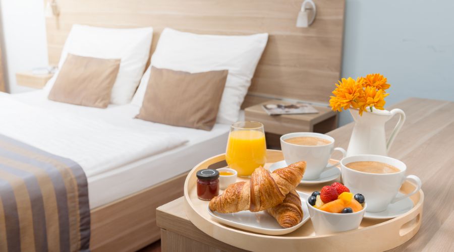 Breakfast tray in cozy hotel room setting.