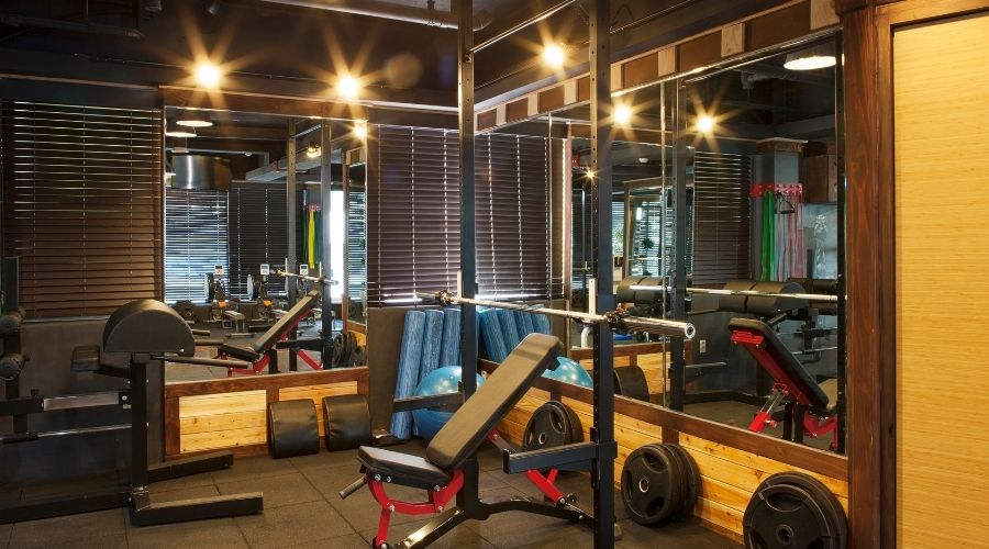 Modern gym with weights and exercise equipment.