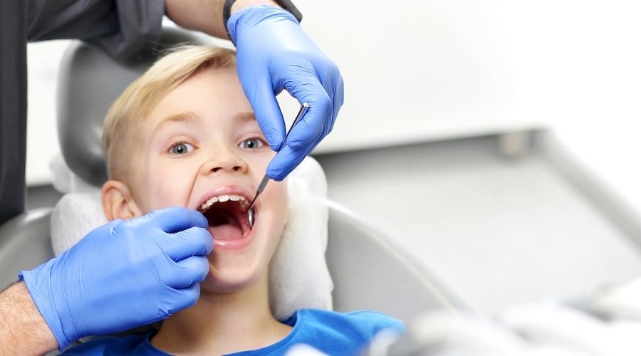 Child receiving dental checkup from dentist.