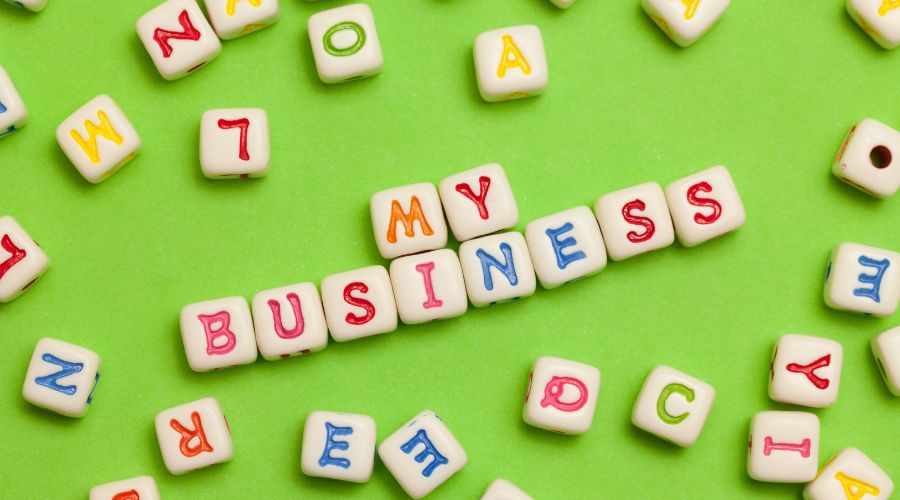 Letter tiles spell 'My Business' on green background.