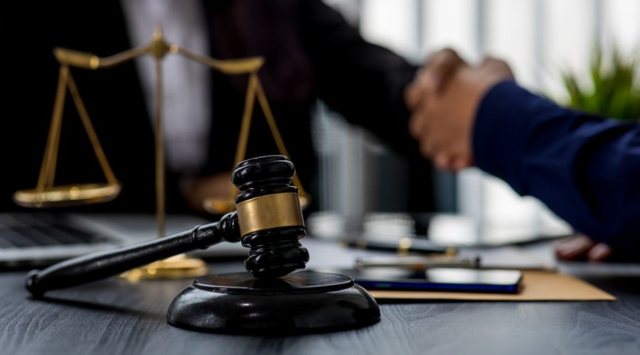 Gavel with scales, people shaking hands