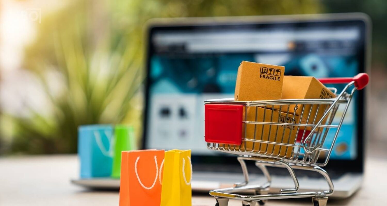 Online shopping concept: cart, boxes, laptop, bags.