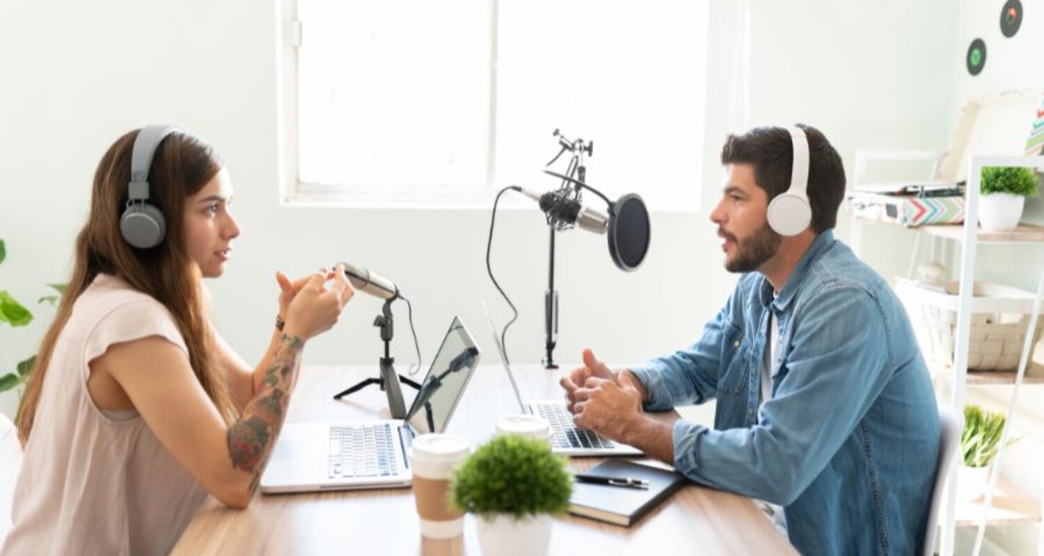 Two people recording podcast in studio setting.