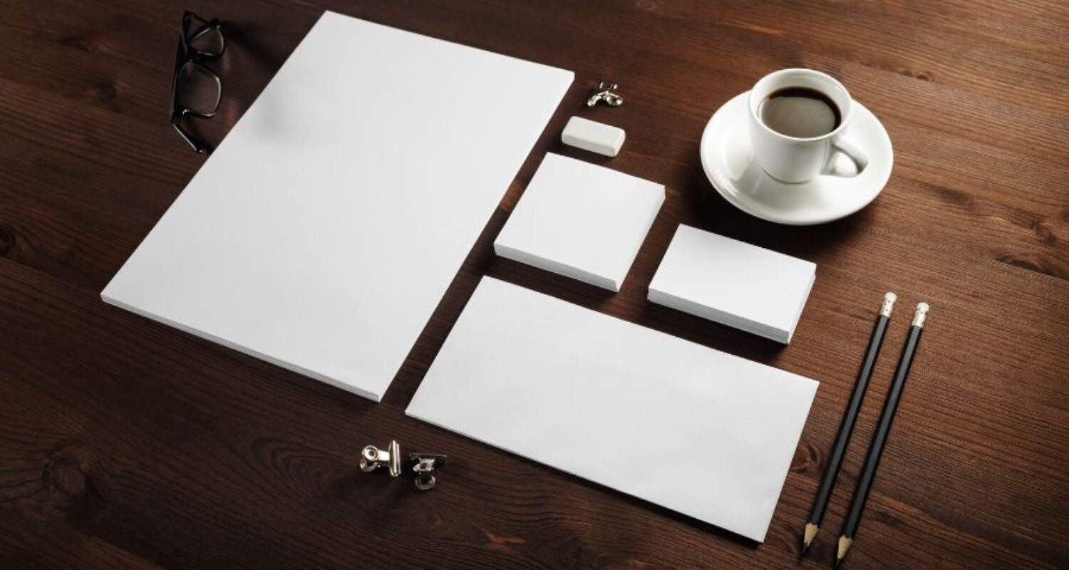 Office stationery on wooden desk with coffee.