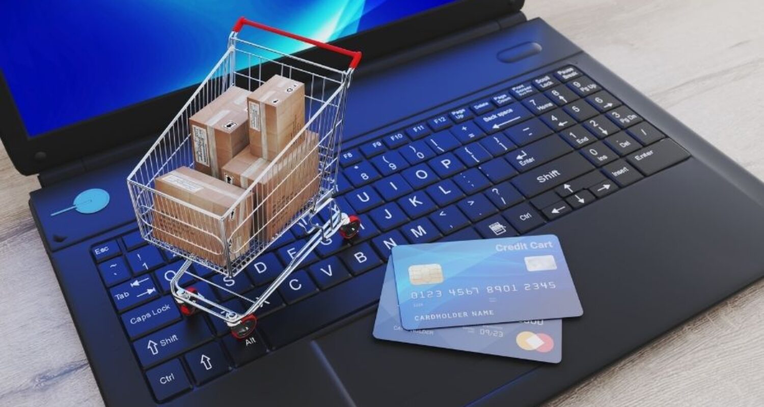 Online shopping concept with cart on laptop.