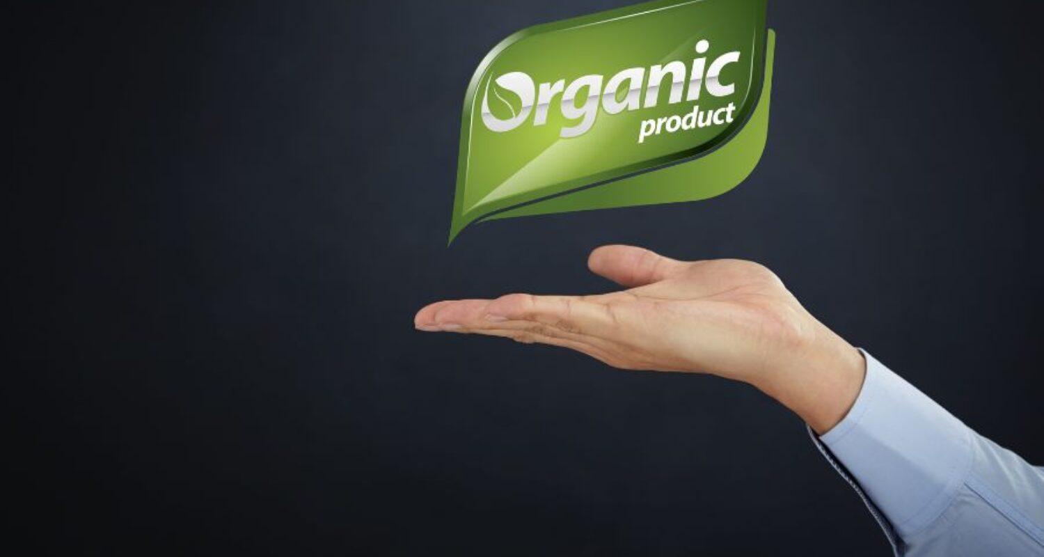 Hand holding organic product label graphic.