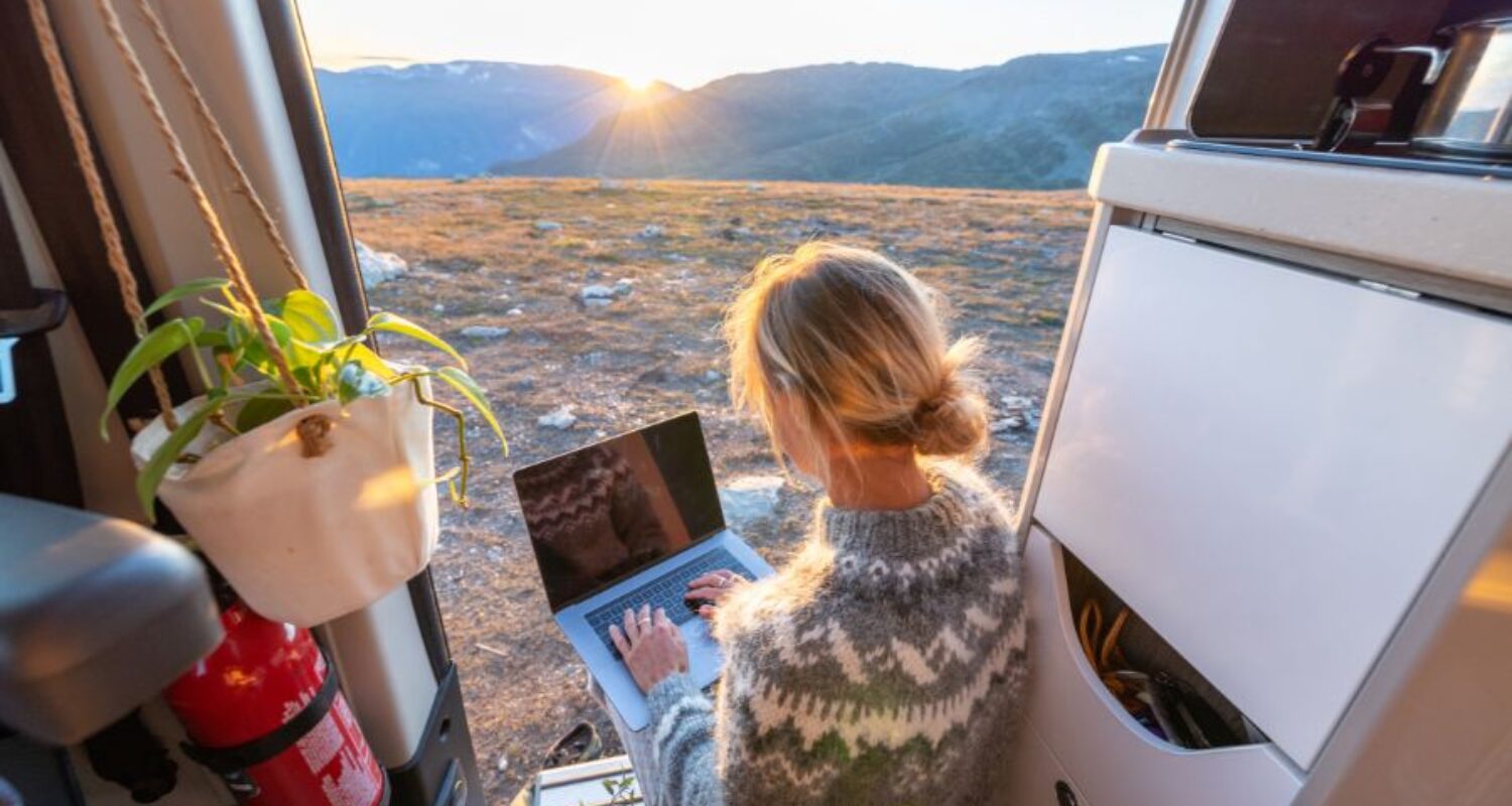 Person working remotely from a van during sunrise.